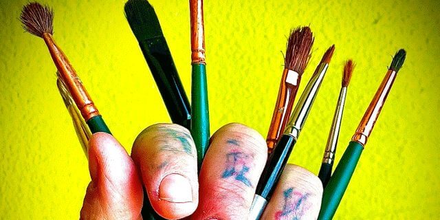 Hand with paint brushes