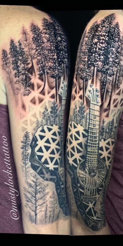Black and grey tattoo trees and guitar