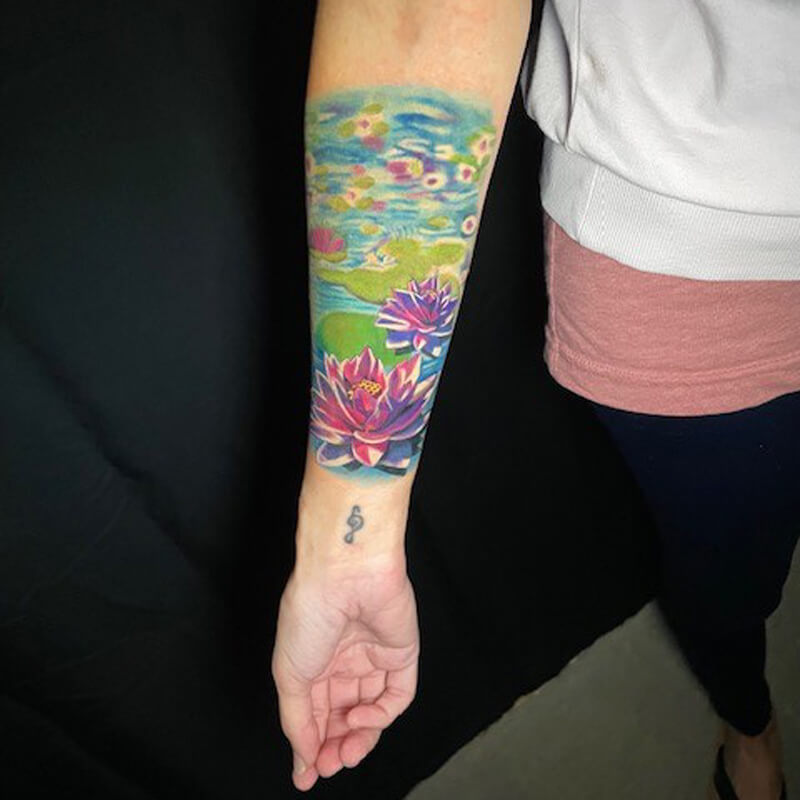Color floral pond tattoo on arm